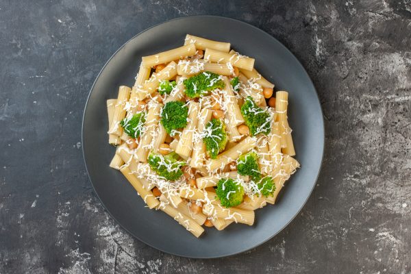top view cooked pasta with cheese and broccoli on light gray bac
